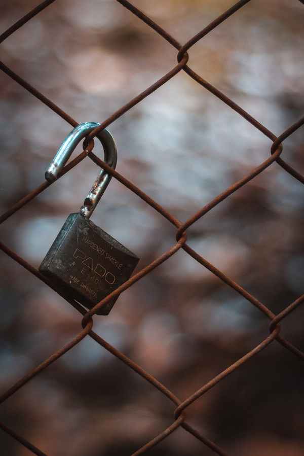open-padlock-hanging-from-chainlink-fence.jpg